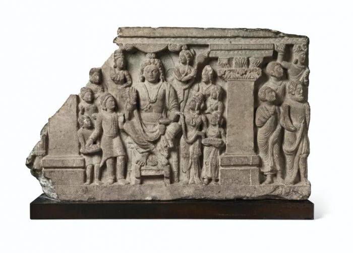 灰片岩浮雕弥勒菩萨与信众，犍陀罗古国，公元三至四世纪，高 41.9 cm，宽 68.9 cm.，估价：60,000-80,000美元。此作将于2020年9月23日在佳士得纽约私人珍藏犍陀罗佛教造像专场拍卖中呈献