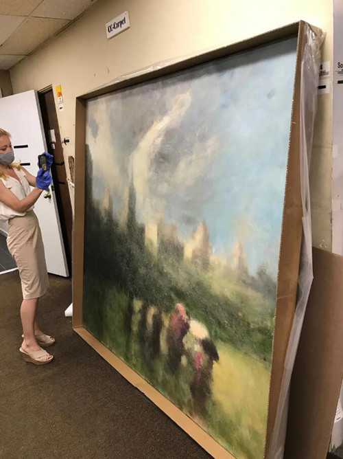 Amanda McConaha of Jackie SilvermanAssociates appraising an artwork for acollector insured by Pure Insurance