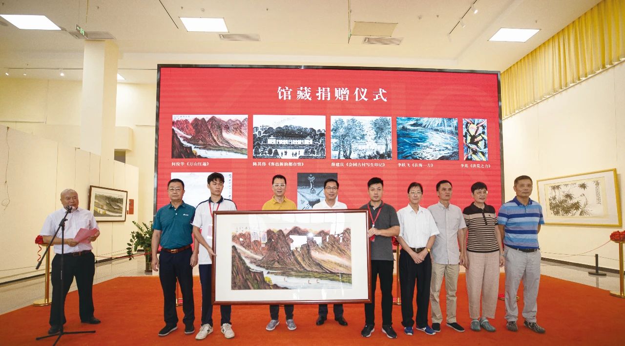 肇庆学院党委书记谢冠华代表肇庆美术馆接收捐赠艺术家代表何俊华捐赠的馆藏作品